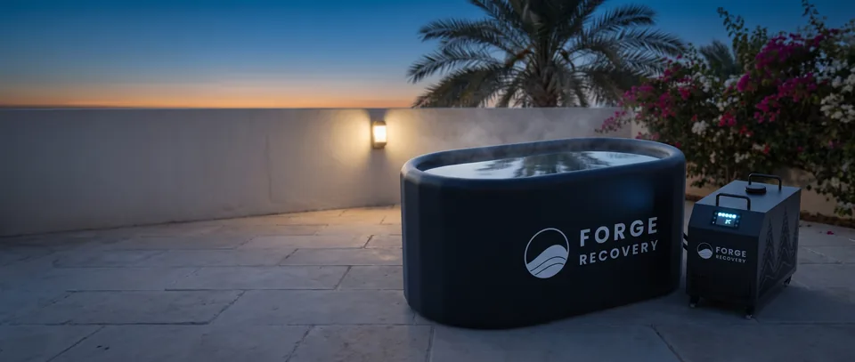 A Forge Recovery cold plunge on a terrace at dusk, chiller beside the tub